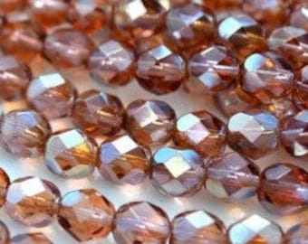 May include: A strand of iridescent brown faceted glass beads. The beads have a slightly rounded shape and are approximately 6mm in diameter.