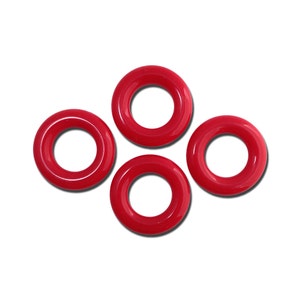 May include: Four red plastic rings, each with a circular hole in the center. The rings are arranged in a diamond shape.
