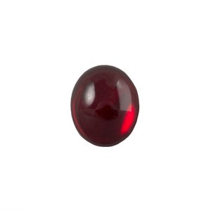 Op de afbeelding: Een ronde, rode, glazen cabochon edelsteen.