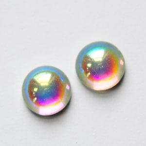 May include: Two iridescent round glass cabochons with a rainbow sheen.
