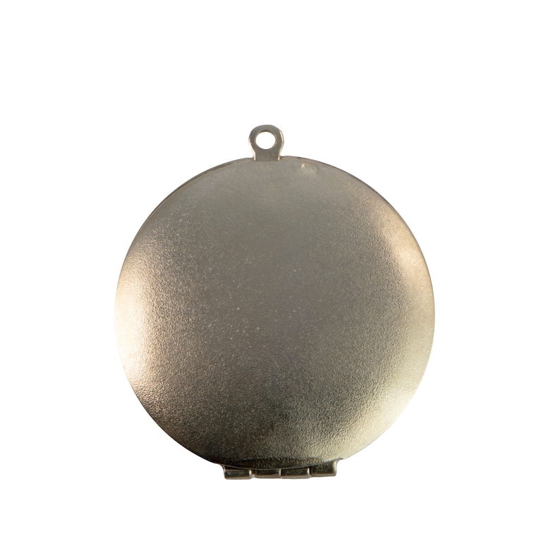 May include: A silver locket with a hinged lid and a smooth, rounded surface.