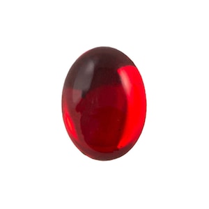 May include: A vibrant, oval-shaped, red gemstone with a glossy finish. The gem has a dark, almost black, top and transitions to a bright, translucent red. The shape is smooth and rounded, suggesting it could be a cabochon or a polished stone.
