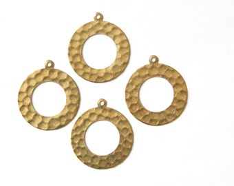 May include: Four brass-colored, hammered-texture circle pendants with small loops at the top for jewelry making. The pendants have a circular cutout in the center. The pendants are on a white background.