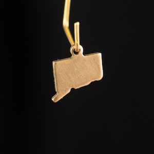 May include: Gold charm in the shape of the state of Connecticut.