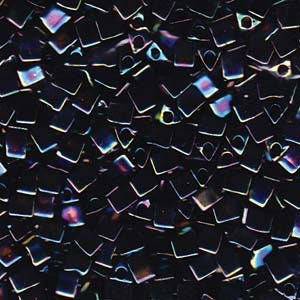 Op de afbeelding: Een close-up van iriserende zwarte vierkante kralen met een gat in het midden. De kralen zijn in een willekeurig patroon gerangschikt.