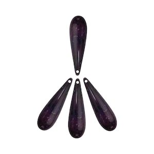 Puede incluir: Cinco cuentas de vidrio en forma de lágrima de color morado oscuro con un patrón moteado. Las cuentas tienen un agujero en la parte superior para enhebrar.