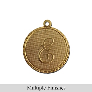 Peut inclure: Breloque en métal doré avec une lettre 'E' en cursive sur un fond texturé. Le breloque a un bord festonné et une boucle pour l'attacher à un collier ou un bracelet.