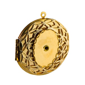 May include: A gold locket with a delicate, intricate design featuring a repeating leaf pattern. The locket has a hinged opening and a small loop at the top for attaching a chain.
