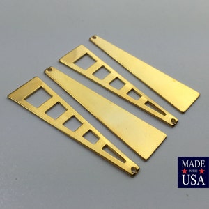 以下が含まれることがあります： 切り抜かれた正方形のある、金色の金属製の三角形のペンダントが4つ。ペンダントの上部には吊り下げ用の穴があります。アメリカ製