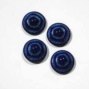 Puede incluir: Cuatro botones de cerámica azul con un diseño de círculo concéntrico blanco.