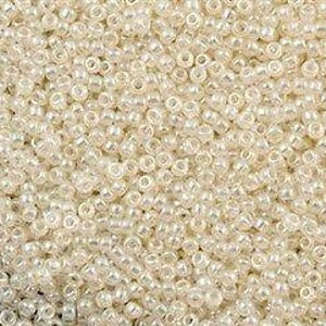 May include: A large quantity of small, white, round seed beads with a slight iridescent sheen.