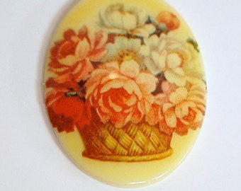 May include: Oval-shaped decorative item with a floral design. The image features a basket filled with orange, red, and white flowers. The background is a pale yellow color, and the item has a glossy finish.