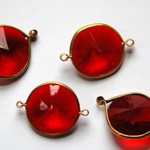 Puede incluir: Cuatro cuentas de vidrio rojo con engastes de metal dorado. Las cuentas son redondas y tienen un diseño facetado. Los engastes tienen un bucle a cada lado para sujetarlas a un collar o pulsera.