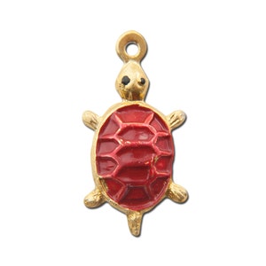 Op de afbeelding: Een gouden schildpadbedel met een rode emaille schild. De schildpad heeft zwarte ogen en een kleine lus aan de bovenkant om aan een ketting of armband te bevestigen.