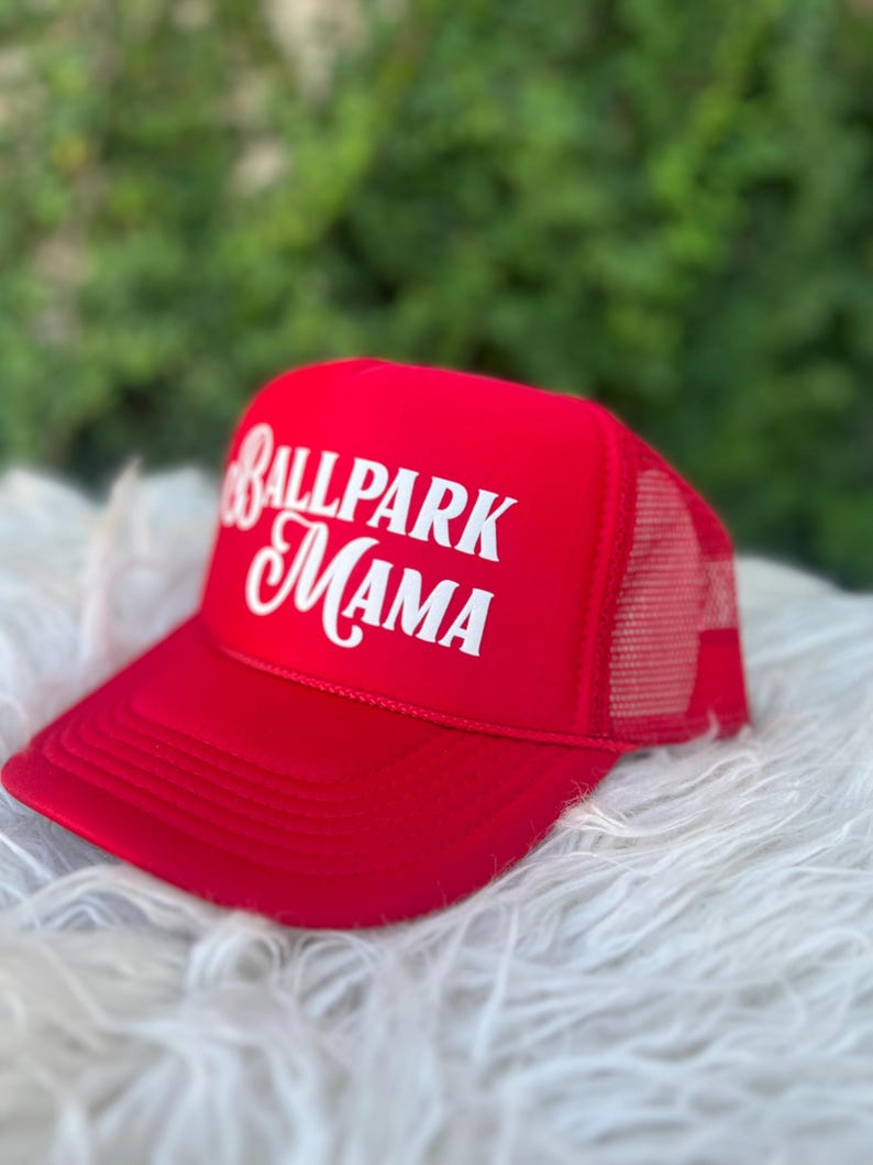 Puede incluir: Gorra de camionero roja y blanca con el texto "Ballpark Mama" en letras blancas.