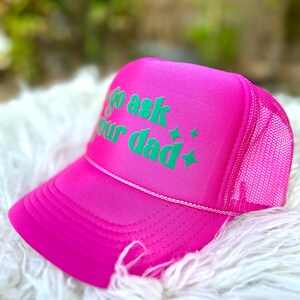 K&ouml;nnte beinhalten: Rosafarbener Trucker-Hut mit einem gr&uuml;nen gestickten Design, auf dem "Go ask your dad" steht.
