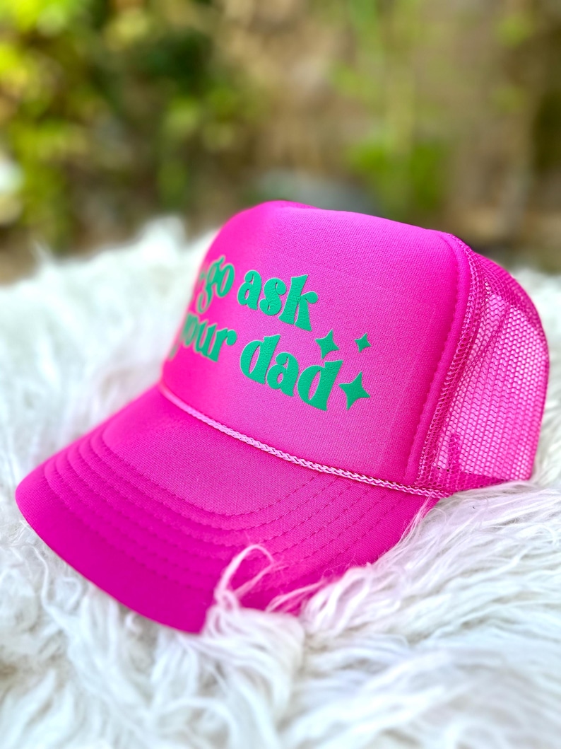 K&ouml;nnte beinhalten: Rosafarbener Trucker-Hut mit einem gr&uuml;nen gestickten Design, auf dem "Go ask your dad" steht.