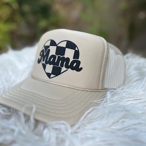 May include: A beige trucker hat with a black and white chequered heart and the word "Mama" in a retro font.