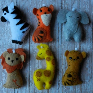May include: Six felt animal toys, including a zebra, tiger, elephant, lion, giraffe, and cheetah. The toys are all handmade and have a cute, cartoonish style.