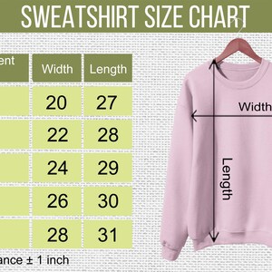May include: A light pink crewneck sweatshirt displayed on a hanger next to a size chart titled SWEATSHIRT SIZE CHART. The chart lists sizes S through 2XL with corresponding width and length measurements in inches, noting a size tolerance of 1 inch.