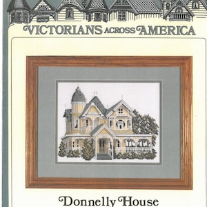 May include: Cross stitch pattern of a yellow Victorian house with a white picket fence and green trees. The pattern is titled "Donnelly House, Mt. Dora, Florida" and is part of the "Victorians Across America" series.