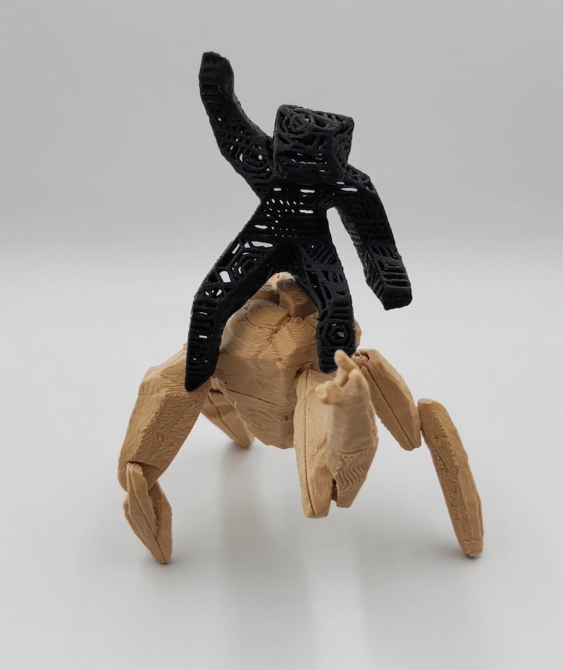 May include: A 3D-printed sculpture featuring a black, open-work figure riding atop a tan, articulated creature with multiple legs. The black figure has its arm raised. The tan creature has a textured surface.