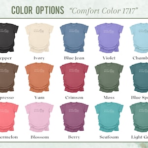 May include: A display of Comfort Color 1717 t-shirts in various colors, including Pepper, Ivory, Blue Jean, and Violet. Each shirt has the text "Just Married" printed on the front. Other colors include Espresso, Yam, Crimson, Moss, and more.