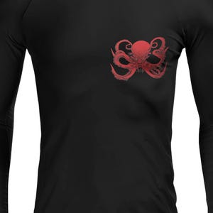 May include: Black long-sleeve shirt with a red octopus graphic on the chest. The octopus design features detailed tentacles and a central head. The shirt is made of a smooth, dark fabric.