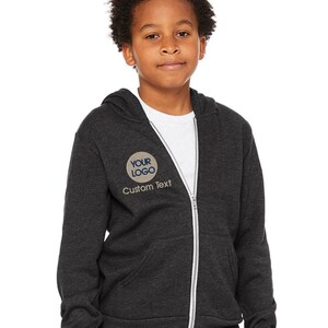a young boy wearing a black jacket and jeans