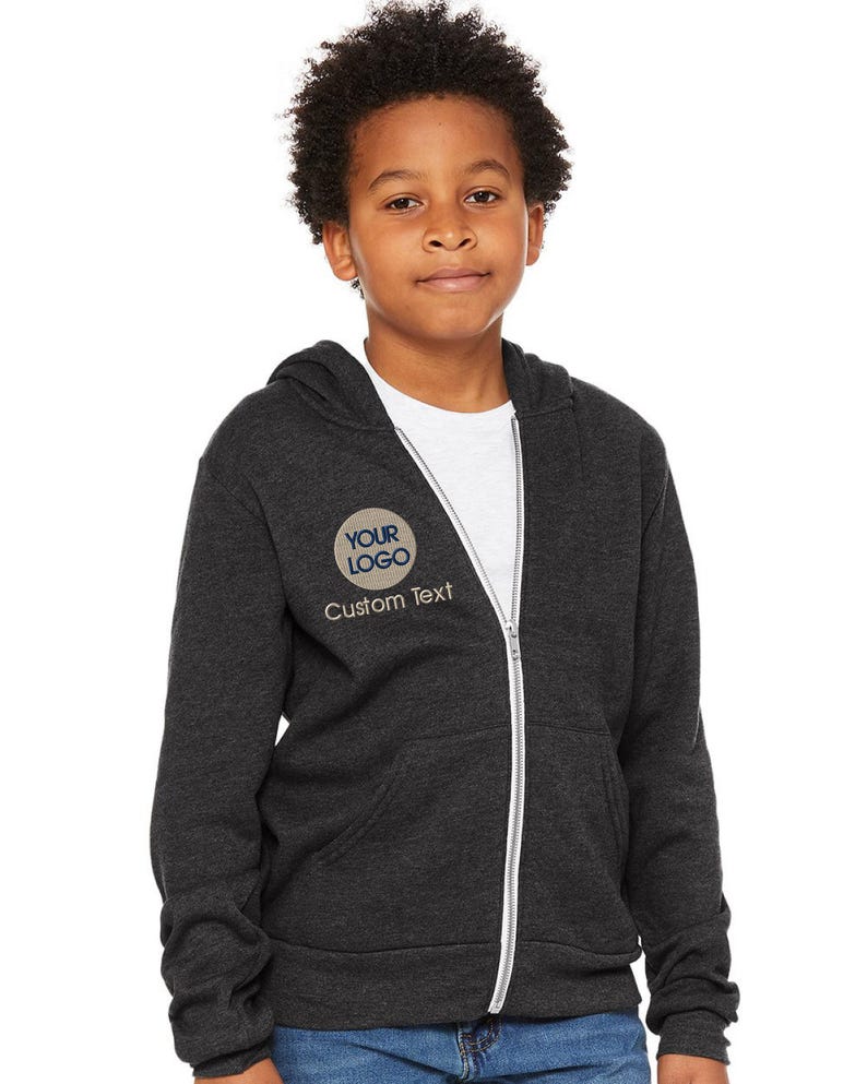 a young boy wearing a black jacket and jeans