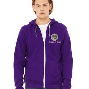 a young man wearing a purple zip up hoodie
