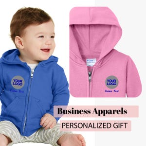 May include: Two baby hoodies, one blue and one pink, with a white circle and the text "YOUR LOGO" in blue. The text "Custom Text" is below the logo.  The hoodies are zippered and have a hood.