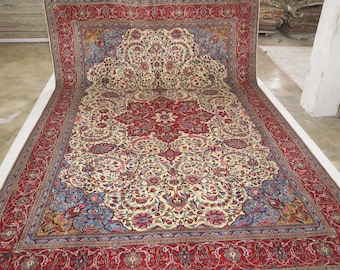 May include: A large, intricately patterned rug with a cream background and a red center medallion. The rug has a red border with floral and geometric designs.