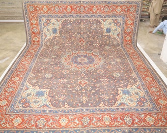 May include: A large, intricately patterned rug with a dark gray background and a central medallion. The rug features a border with red, blue, and cream floral motifs.