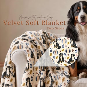 May include: A soft velvet blanket featuring a repeating pattern of Bernese Mountain Dogs, pumpkins, and autumn leaves in blue, orange, and brown. The text on the image reads Bernese Mountain Dog Velvet Soft Blanket Two Sizes.