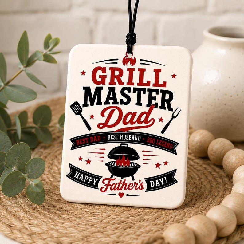 K&ouml;nnte beinhalten: Ein rechteckiges, wei&szlig;es Keramik-H&auml;ngeschild mit schwarzem und rotem Text und Grafiken. Der Text lautet GRILL MASTER Dad, BEST DAD, BEST HUSBAND, BBQ LEGEND und HAPPY FATHER'S DAY. Es zeigt Illustrationen von einem Pfannenwender, einer Gabel und einem Grill.