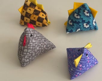 May include: Four handmade fabric chicken toys in various patterns and colors. One chicken is gray with a red comb, another is blue with white flowers, a third is purple with a geometric design, and the last is yellow and brown checkered.