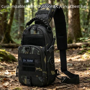 Puede incluir: Una bolsa de pecho con estampado de camuflaje y una sola correa para el hombro, con un asa trenzada negra, múltiples compartimentos con cremallera y un parche rectangular con el texto Dr. Butter. La bolsa incluye correas MOLLE y hebilla.