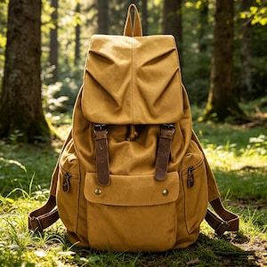 Puede incluir: Mochila de lona color mostaza con correas y detalles de cuero marrón. La mochila tiene un cierre de solapa, dos bolsillos delanteros y correas ajustables para los hombros. La bolsa está diseñada para uso en exteriores y tiene una estética vintage.