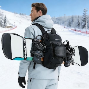 Może przedstawiać: Osoba w jasnoszarej kurtce i czarnych rękawicach trzyma czarną deskę snowboardową z białymi i turkusowymi akcentami. Deska snowboardowa jest trzymana z czarnymi wiązaniami, a czarny plecak z napisem "FLOWTHEORY" znajduje się na plecach.