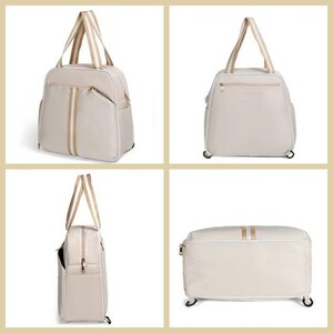 May include: A beige travel bag with a rectangular shape, featuring two vertical stripes and a horizontal stripe in a lighter beige colour. The bag has two handles and a zip closure. The bag has wheels.