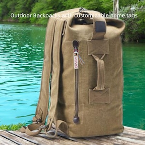 Puede incluir: Una mochila de lona color canela con cremallera y asa. La mochila tiene correas ajustables y una pequeña etiqueta con la palabra "YOYO" impresa. El fondo es una masa de agua.