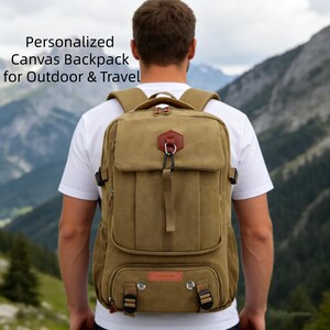 Könnte beinhalten: Khaki-farbener Canvas-Rucksack mit mehreren Taschen und verstellbaren Trägern, geeignet für Outdoor-Aktivitäten und Reisen. Der Text "Personalized Canvas Backpack for Outdoor & Travel" ist im Bild zu sehen.