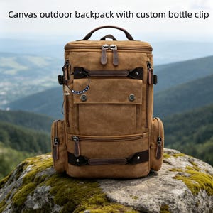 Op de afbeelding: Een bruine canvas outdoor rugzak met een aangepaste flessenclip, voorzien van meerdere vakken met rits, donkerbruine kunstlederen accenten, een handvat aan de bovenkant en de tekst "Canvas outdoor backpack with custom bottle clip" erboven.