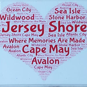 K&ouml;nnte beinhalten: Eine quadratische wei&szlig;e Kachel mit einem herzf&ouml;rmigen Design, das mit rotem Text gef&uuml;llt ist. Der Text enth&auml;lt die W&ouml;rter "Jersey Shore", "Cape May" und andere K&uuml;stenst&auml;dte. Der Satz "Where Memories Are Made" ist ebenfalls enthalten.