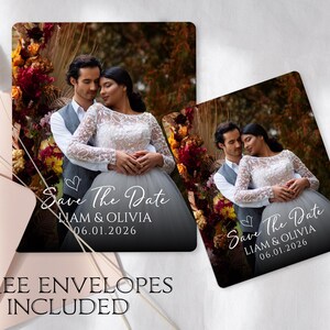 May include: Square wedding announcement cards featuring a couple embracing, with the text "Save The Date" and the names "Liam & Olivia" along with the date "06.01.2026". The cards are set against a background of a blurred outdoor scene.