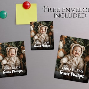May include: Three rectangular magnets showing a baby in a bear costume, surrounded by soft toys. The magnets have the text "GOD BLESS Travis Phillips" in white. The words "FREE ENVELOPES INCLUDED" are above the magnets.