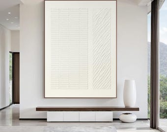 Op de afbeelding: Groot, ingelijst abstract kunstwerk met een getextureerd, gebroken wit oppervlak. Het kunstwerk heeft twee verticale panelen, één met een rasterpatroon en de andere met diagonale lijnen. De lijst is donkerbruin.