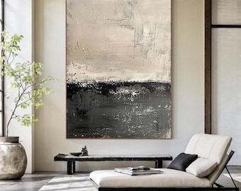 Op de afbeelding: Abstract textuurschilderij in een neutraal kleurenpalet. Het kunstwerk heeft een gelaagde compositie met een textuuroppervlak, met tinten grijs, zwart en gebroken wit. Het schilderij wordt tentoongesteld in een moderne woonruimte.