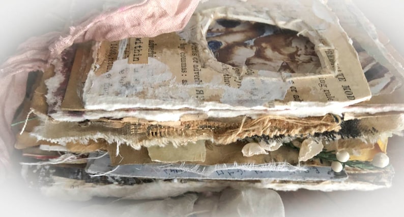 May include: A stack of paper and fabric pages with a vintage feel. The pages are layered and distressed, with visible text and images. The top page has the text "FREEDOM - THE HOD" and "ing rule".